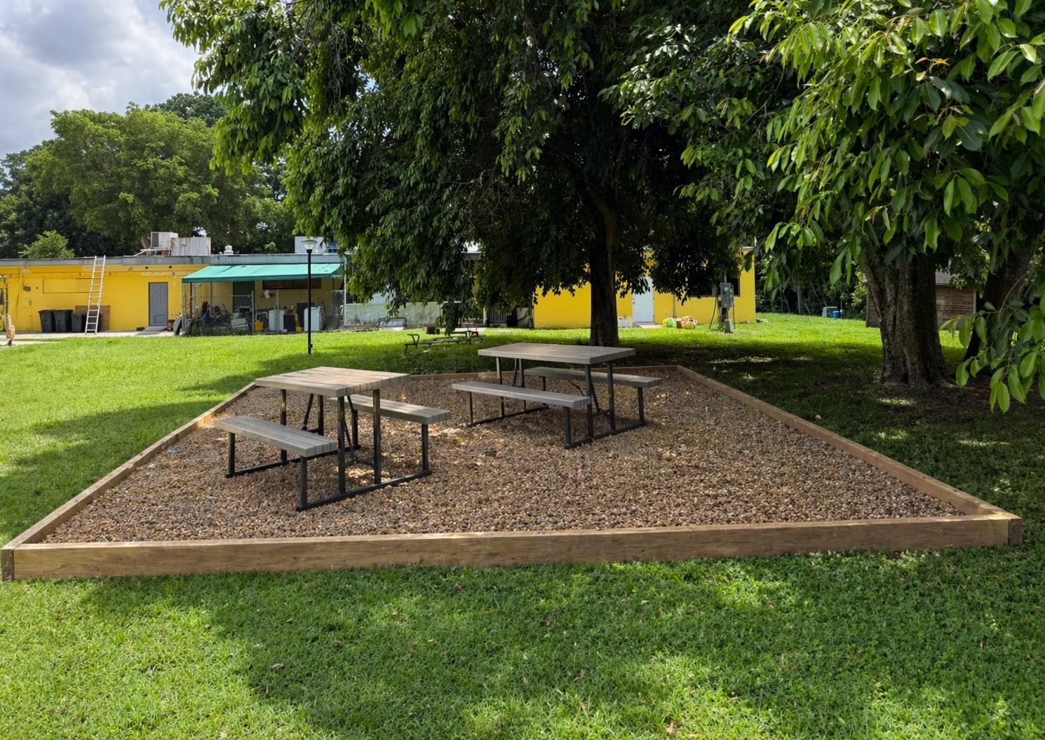 Proposed visualization showing a timber-bordered gravel surface and picnic benches
